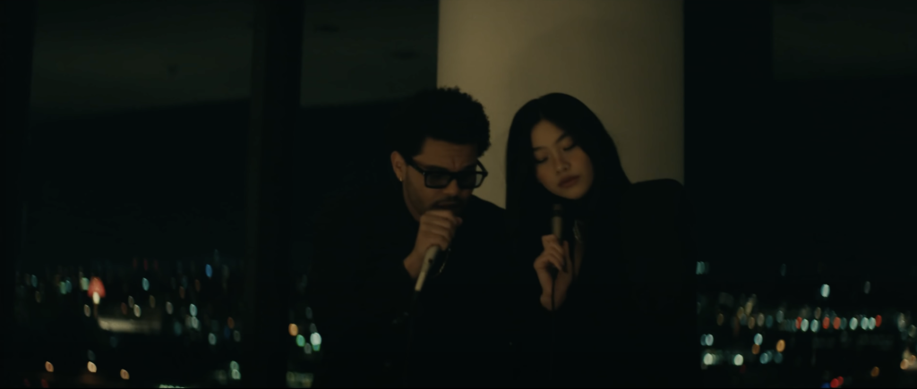 The Weeknd dropped the official music video for his hit song “Out of Time” on Tuesday, and the two guest appearances were everything. Starring opposite Squid Game star Jung Ho-yeon, The Weeknd engages in a night of karaoke and playful flirtation with his newfound love interest. 