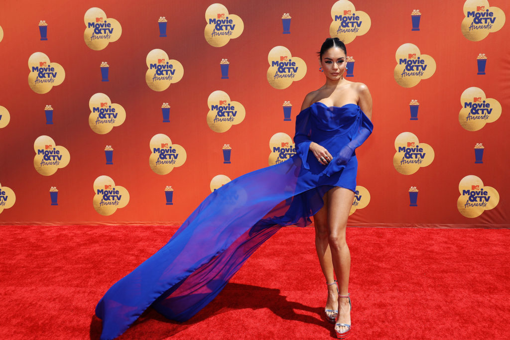Before the night started, Hudgens hit the carpet in a gorgeous custom royal blue Vera Wang mini-dress. She paired the dress with silver platform heels to match her silver hoop earrings. The look was completed with a slick back middle-part bun and a subtle light-blue smokey eye. Hudgens posted the look to her Instagram and captioned it, “Mother Nature blessed me and my custom @verawang 🥰🥰 now to get ready to host the @mtv awards!!!! 🥳”