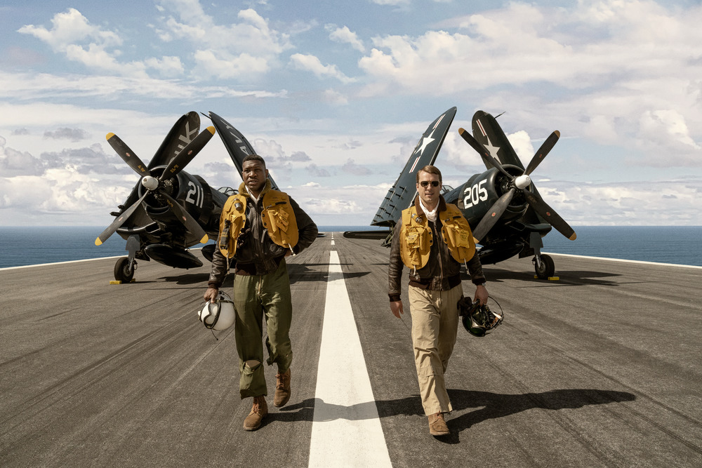 Glen Powell (Top Gun: Maverick) stars as Tom Hudner, the wingman for Jonathan Majors’ (Lovecraft Country, The Harder They Fall, Loki) real-life character Jesse Brown, the first Black aviator in Navy history in Sony Pictures’ Devotion. 