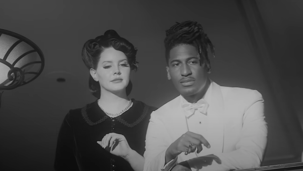 Lana Del Rey channels old Hollywood glamour in her haunting new music video for “Candy Necklace” featuring Grammy-winning artist, Jon Batiste.