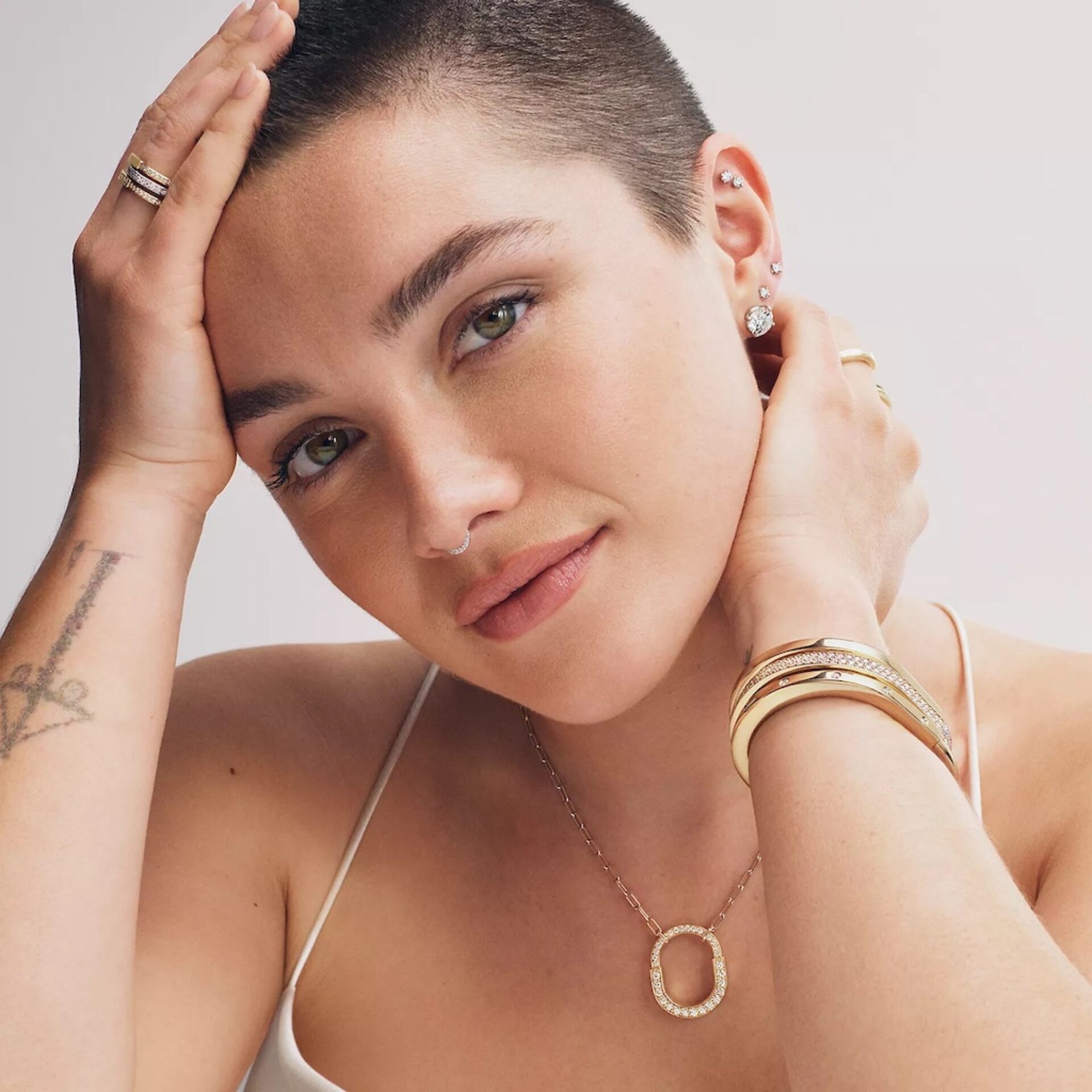 Florence Pugh brings back her signature Met Gala buzz cut for Tiffany and Co.'s latest campaign. The Oppenheimer star adds elegance to the new 'Lock' designs.