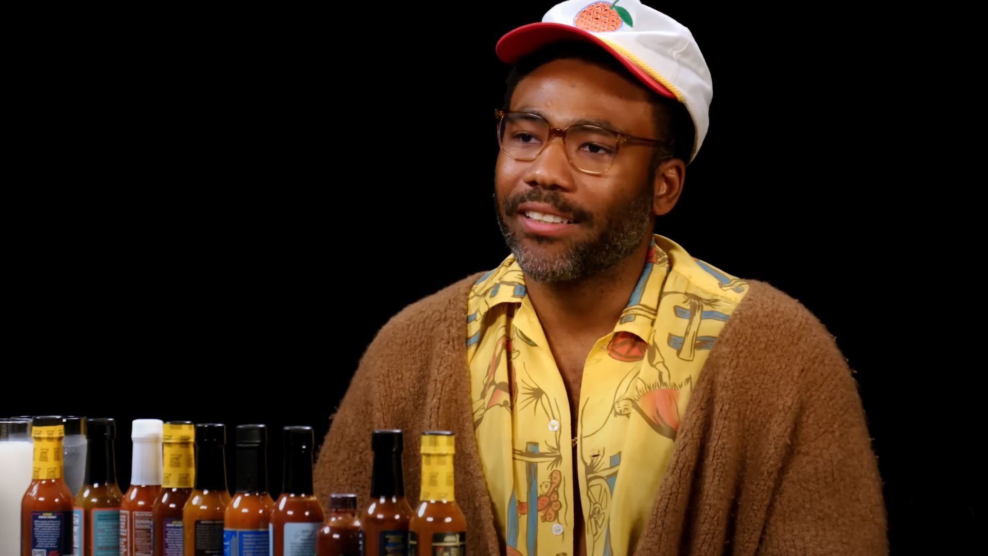 Donald Glover appears on the newest episode of 'Hot Ones,' comparing the hot wings challenge to an Ayahuasca trip.